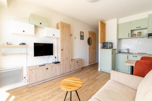 un salon avec un canapé et une cuisine dans l'établissement Studio vue Vieux port Pornic -A011, à Pornic