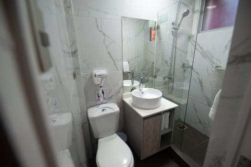 a bathroom with a toilet and a sink and a shower at Hotel Real in Linares