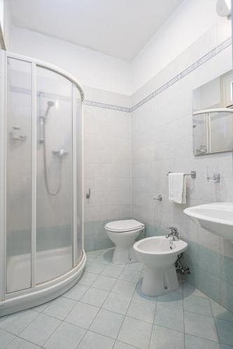 a bathroom with a shower and a toilet and a sink at Hotel Altamarea Cesenatico in Cesenatico