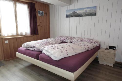 a bedroom with a bed with purple and white sheets at Apartment Alpenblick in Saas-Grund
