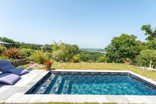 a swimming pool in the yard of a house with two chairs at L'Atelier de Scarlett 