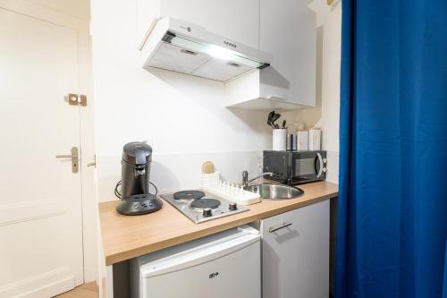 a small kitchen with a sink and a stove at THEM'APPARTS BORDEAUX Sainte Croix in Bordeaux