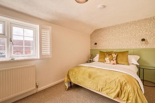 une chambre avec un lit et une fenêtre dans l'établissement Winterton Sea Sanctuary, Hot Tub & Log Burner by the Dunes, à Winterton-on-Sea