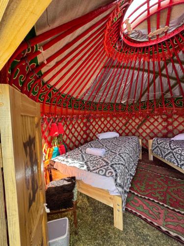 een slaapkamer met een bed in een rode tent bij One Million Stars Yurt camp in Song-Kul