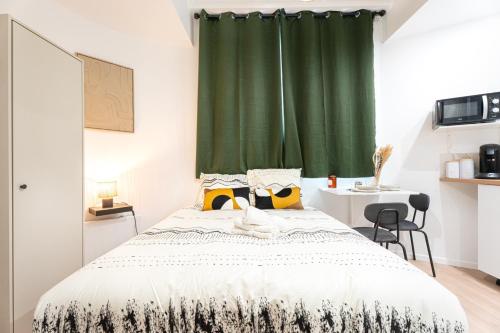 a bedroom with a bed with a green curtain at THEM'APPARTS BORDEAUX Sainte Croix in Bordeaux