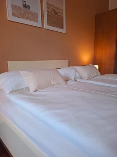 two beds in a bedroom with white sheets and pillows at Johnys Jungle in Marbach an der Donau