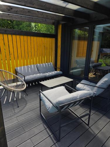 a patio with a table and chairs on a deck at Polana Jelenia Głowa in Wambierzyce