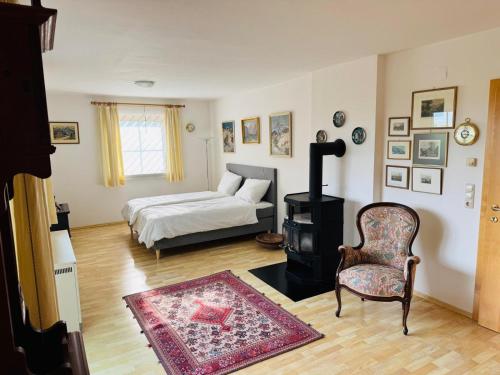 a bedroom with a bed and a chair and a table at Lisa & Gretl's Alpen-Panorama Chalet Saalfelden - 10 Min nach Zell am See in Saalfelden am Steinernen Meer