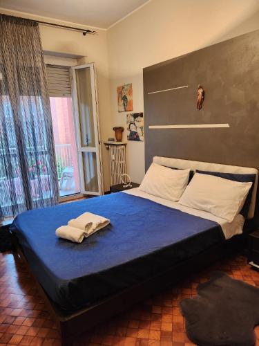a bedroom with a large bed with a blue sheet at CASA TIO PIERO Centrale accogliente e confortevole in Asti