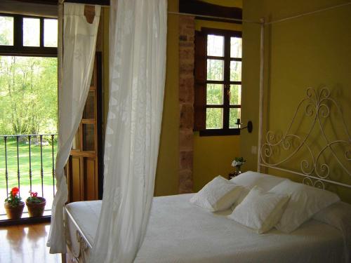 a bedroom with a white bed and a window at Casona de San Pantaleón de Aras in San Pantaleón de Aras