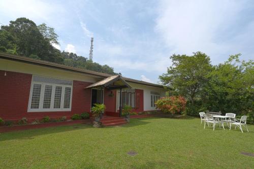 a house with chairs and a table in the yard at The Bungalow - Rathnapura in Ratnapura