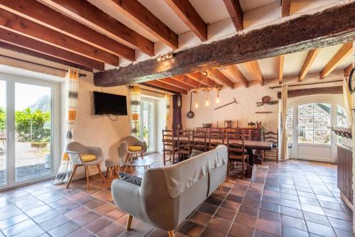 un grand salon avec une table et des chaises dans l'établissement Au Milan D'ore - Pyrénées, à Gère-Belesten