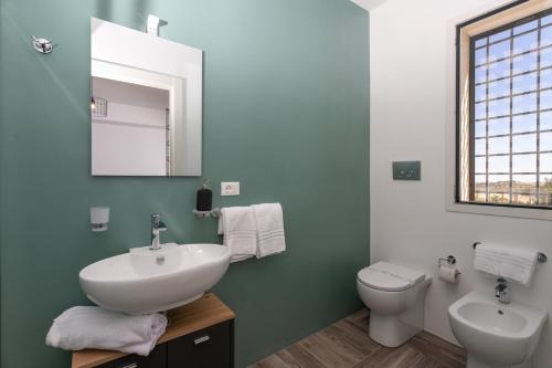 a bathroom with a sink and a toilet and a mirror at Dimora degli Ulivi 10 Emma Villas in Noto