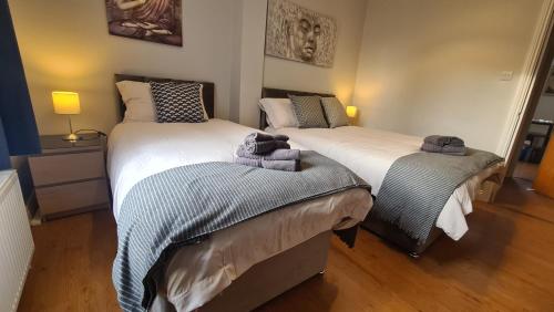 a bedroom with two beds with towels on them at Waterworks En suite Rooms with Private Living Room in Belfast