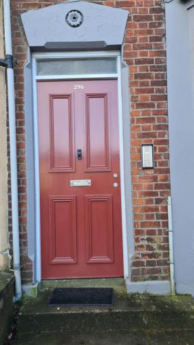 a red door on the side of a brick building at Waterworks En suite Rooms with Private Living Room in Belfast