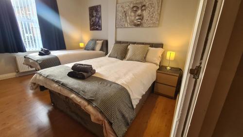 a bedroom with two beds and a headboard at Waterworks En suite Rooms with Private Living Room in Belfast