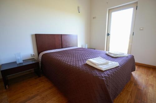 a bedroom with a bed with two towels on it at Douro Natura in Bemposta