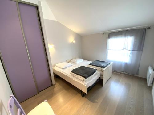 une petite chambre avec deux lits et une fenêtre dans l'établissement A quelques pas de la plage, à La Tranche-sur-Mer