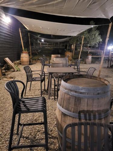 a group of chairs and tables and a table with a barrel at VioVillas Agriturismo Glamping Arezzo in Arezzo
