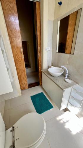 a bathroom with a sink and a toilet and a mirror at Tiny House Noronha in Fernando de Noronha