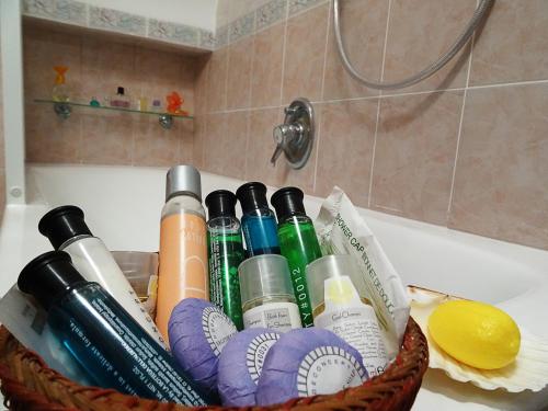 un cesto di prodotti per la pulizia posto su una vasca da bagno di Casa Ilaria - Appartamento in Piazzetta a Capri