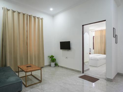 a living room with a couch and a television at Thamosa Stays in Jaipur