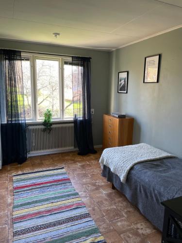 a bedroom with a bed and a large window at Hus på bondgård in Gunnarskog