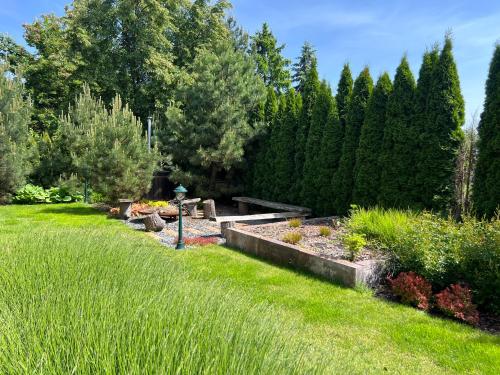 a garden with a row of plants and trees at Jantarvia Car Museum , Pasja i Wypoczynek Noclegi z Klimatem in Jantar