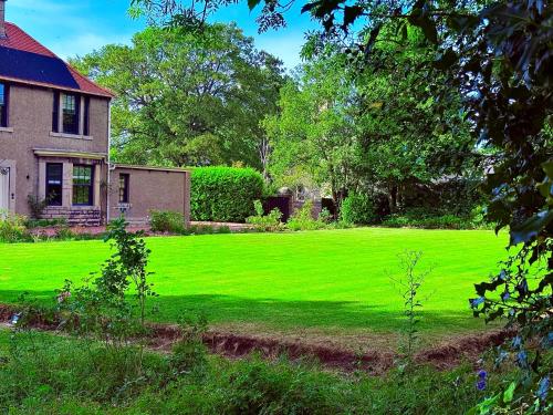 a house with a yard with a green lawn at Red Roofs - 5BR Luxury - Large Gardens - EV Point - Near Edinburgh in Newtongrange