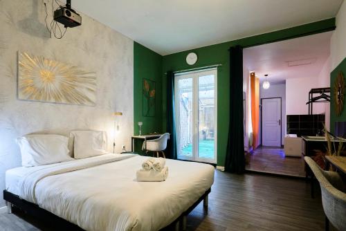 une chambre avec un grand lit avec deux serviettes dessus dans l'établissement NG Prestige - Lille I Roubaix Centre - 121 - Balnéo - Kitchenette - Terrasse - WIFI - NETFLIX, à Roubaix