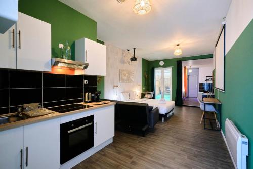 - une cuisine aux murs verts et un lit dans une chambre dans l'établissement NG Prestige - Lille I Roubaix Centre - 121 - Balnéo - Kitchenette - Terrasse - WIFI - NETFLIX, à Roubaix