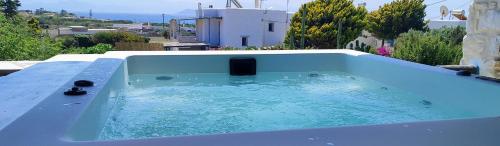 a large blue bath tub sitting on top of a house at Island Magic - Seaview Villa with Jacuzzi Pool in Ambelas
