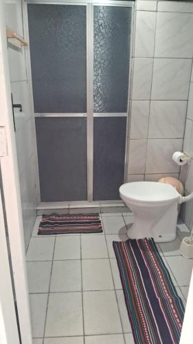 a bathroom with a shower with a toilet and a rug at Casa Recanto do Vale in Guapimirim