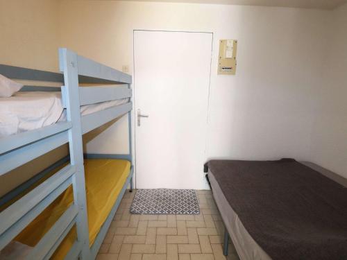 Cette petite chambre comprend des lits superposés et une porte. dans l'établissement Studio avec terrasse, piscine, parking et clim au Grau-du-Roi - FR-1-307-256, au Grau-du-Roi