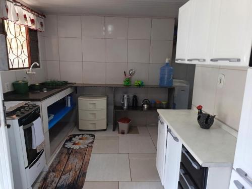 a kitchen with white cabinets and a counter top at Casa Recanto do Vale in Guapimirim