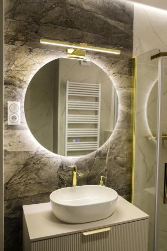 a bathroom with a sink and a mirror at Apartament Valentino Bussines Haven & Family in Kielce