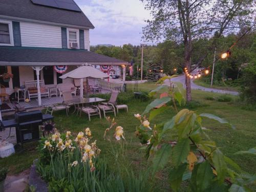 a yard with a house with a table and chairs at 10 Mi to Gore Mountain- Home in Adirondack Park home in Olmstedville