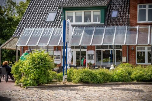a building with a flag in front of it at Ferienhaus Mellumplate 37 in Dorum Neufeld