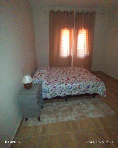 a bedroom with a bed with a dresser and a window at Residência Carlos in Areia Branca