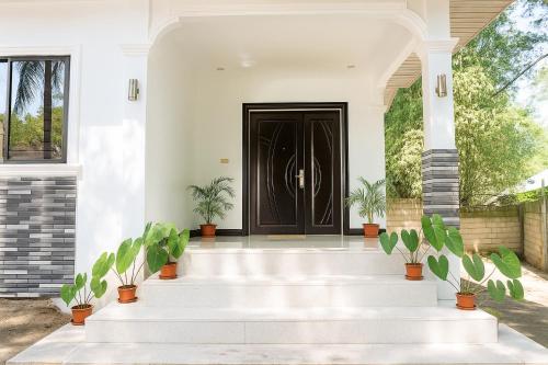a front door of a house with potted plants at Hanella's Place in Bacong