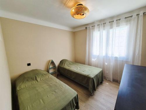 une chambre avec deux lits et une fenêtre dans l'établissement 2 chambres, climatisation, à deux pas de la mer, à La Seyne-sur-Mer