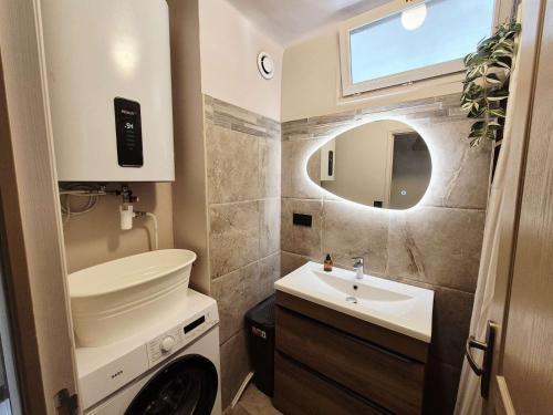 une salle de bain avec un lavabo, des toilettes et un miroir dans l'établissement 2 chambres, climatisation, à deux pas de la mer, à La Seyne-sur-Mer