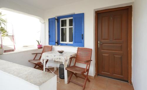 a porch with a table and chairs and a door at Podotas Group in Kamarai
