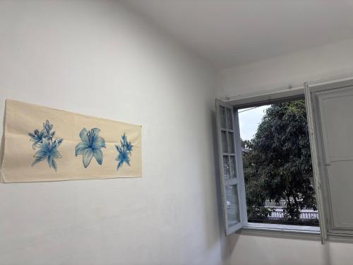 a painting of flowers on a wall next to a window at Encanto Imperial in Petrópolis