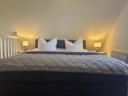 a bedroom with a large bed with white pillows at Fischstübchen Neeberg Fewo 1 - Hase und Fuchs in Krummin