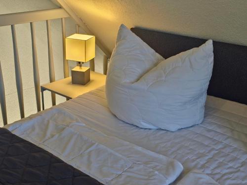 a bed with a large white pillow on it at Fischstübchen Neeberg Fewo 1 - Hase und Fuchs in Krummin