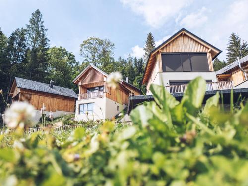 a house in the countryside with trees in the foreground at Hideaway Hotel Montestyria Chalets & Suiten in Mariazell