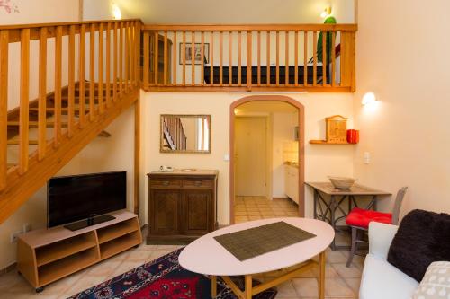 a living room with a staircase and a couch and a table at Appartementhaus Witzmann in Bad Vöslau