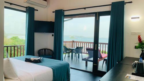 a bedroom with a bed and a balcony at Lucky Monkey Inn and Restaurant in Weligama
