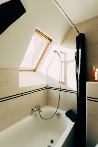 La salle de bains est pourvue d'une baignoire et d'une fenêtre. dans l'établissement Maison Cœur Historique du Vieux Lille de 98m2, à Lille